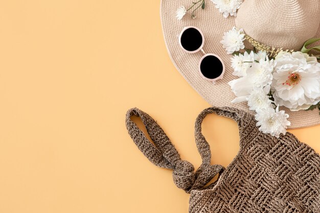 Stijlvol voor de zomer met zomeraccessoires. Rieten hoed, tas en bril.