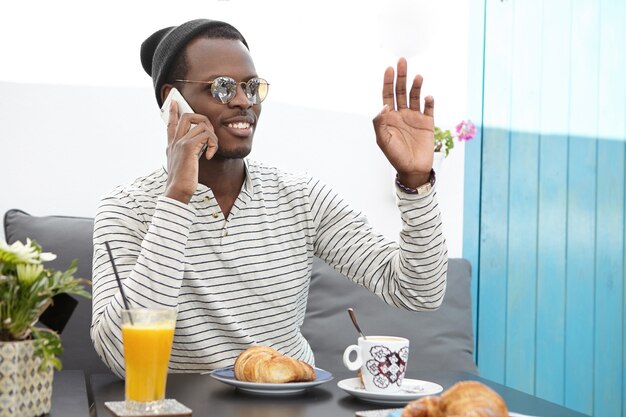 Stijlvolle Afro-Amerikaanse man zit in café