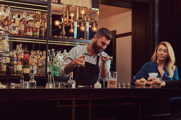 Stijlvolle brute barman bedient een aantrekkelijk stel dat een avond op een date doorbrengt.