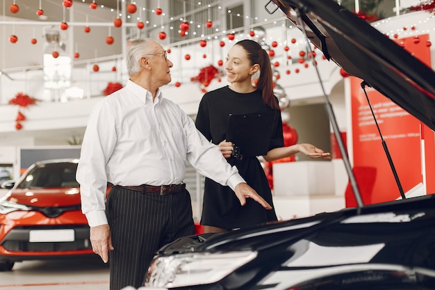 Stijlvolle en elegante oude man in een auto salon