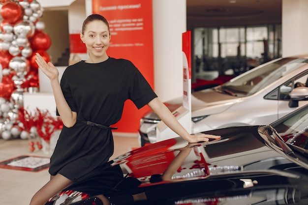 Gratis foto stijlvolle en elegante vrouw in een auto salon