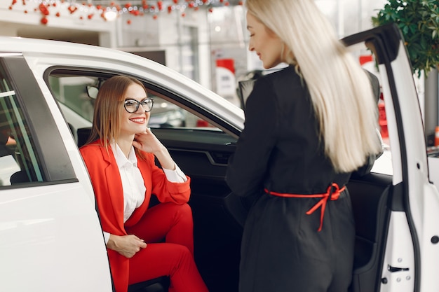 Gratis foto stijlvolle en elegante vrouwen in een autosalon