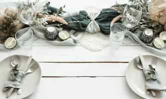 Gratis foto stijlvolle feestelijke tafelsetting met scandinavische decordetails op een houten oppervlak.