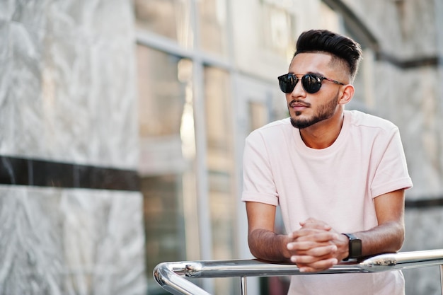 Stijlvolle Indiase baardman met zonnebril en roze t-shirt India-model poseerde buiten in de straten van de stad