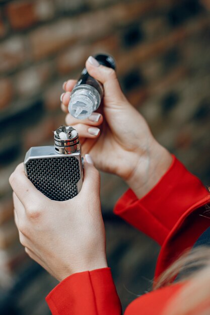 Stijlvolle jong meisje in een stad met vape