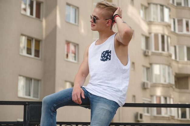 Stijlvolle jonge man met tatoeages en trendy kapsel