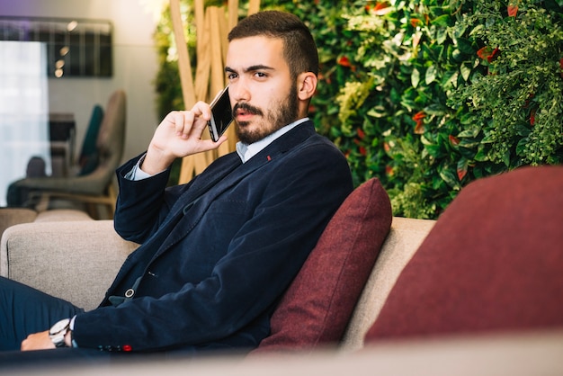 Stijlvolle jonge man met telefoon praten