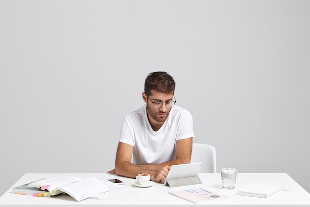 Stijlvolle jonge man zit aan bureau