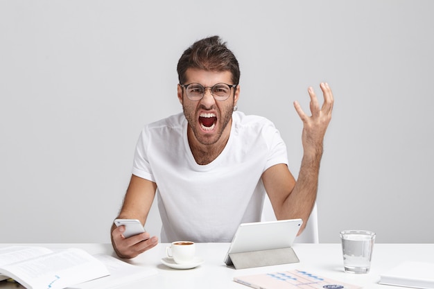 Stijlvolle jonge man zit aan bureau