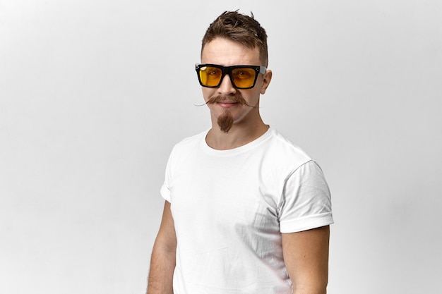 Stijlvolle jongeman met zonnebril en wit T-shirt met een oog