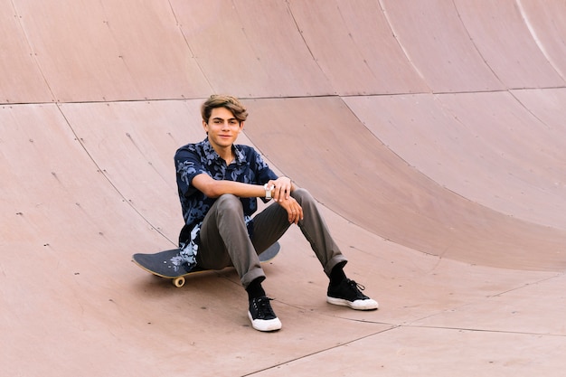 Stijlvolle jongen zittend op skateboard