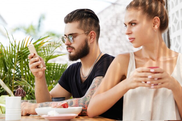 Stijlvolle man en vrouw zitten in café