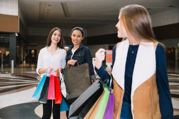 Stijlvolle meisjes die zich in het winkelcentrum bevinden