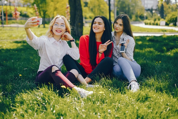 stijlvolle meisjes zitten in een park