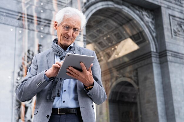 Stijlvolle oudere man in de stad met tablet