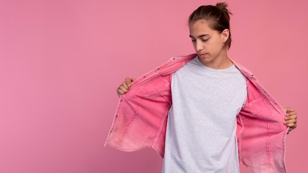 Stijlvolle tienerjongen in roze poseren met kopieerruimte
