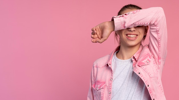 Stijlvolle tienerjongen in roze poseren met kopieerruimte