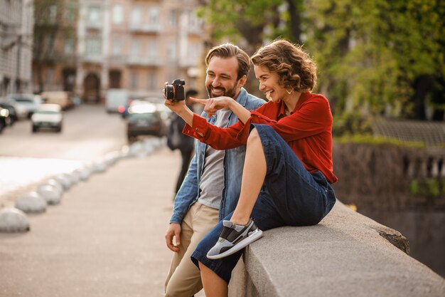 Stijlvolle verliefde paar zittend op straat op romantische reis, foto nemen