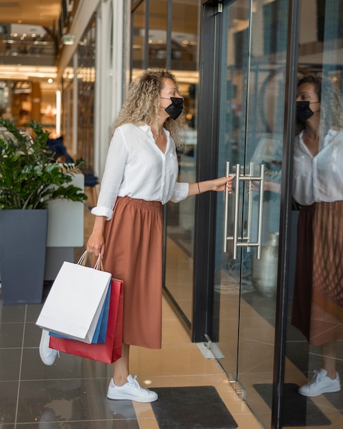 Stijlvolle volwassen vrouw met boodschappentassen