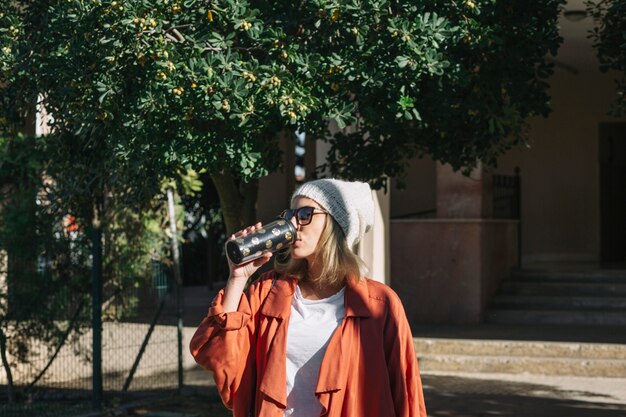 Stijlvolle vrouw drinken op straat