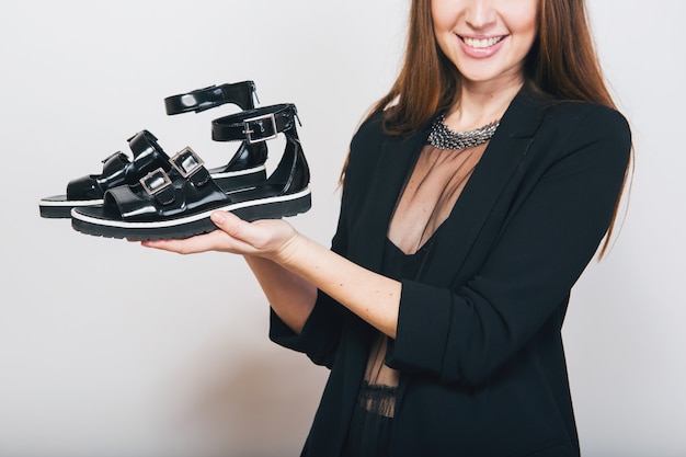 Gratis foto stijlvolle vrouw geïsoleerd in zwart pak met pait schoenen