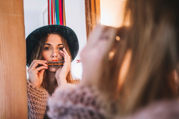 Gratis foto stijlvolle vrouw harmonica spelen