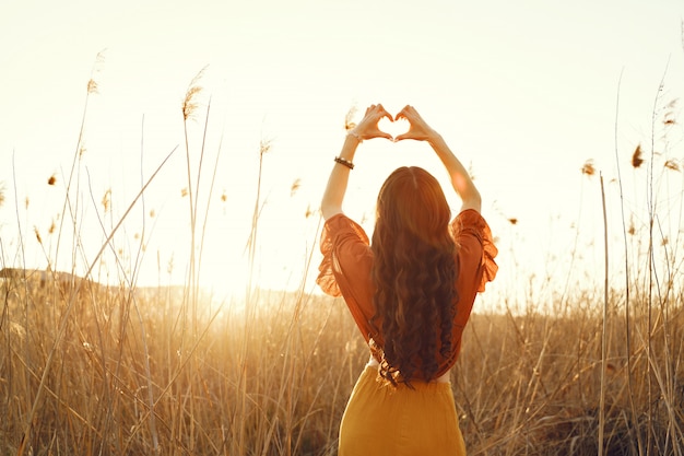 Gratis foto stijlvolle vrouw tijd doorbrengen in een zomer-veld