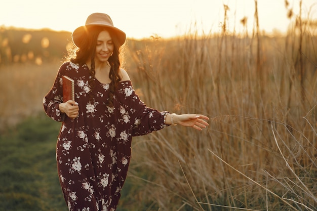 Gratis foto stijlvolle vrouw tijd doorbrengen in een zomer-veld