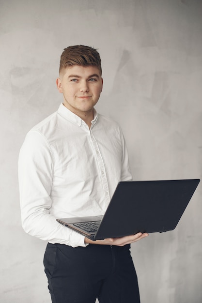 Stijlvolle zakenman die in een kantoor werkt en laptop gebruikt