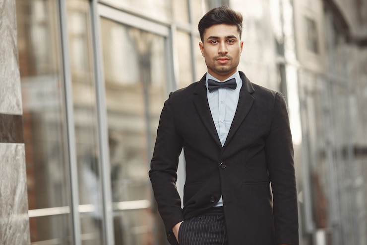 Gratis Foto stijlvolle zakenman in een zwart pak permanent buiten