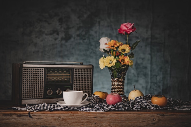 Gratis foto stilleven met bloemenvazen met fruit en retro radio