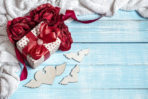 Stilleven met een mooi ingepakt cadeau, bloemen en decoratieve elementen op een houten ondergrond. Valentijnsdag concept vakantie.