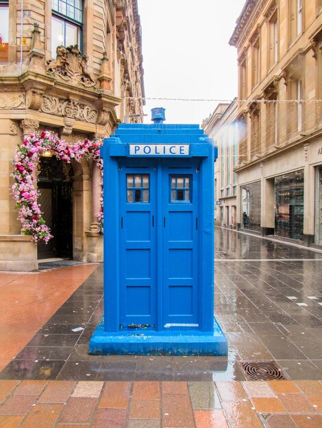 Straat met blauwe politiebox in Glasgow Verenigd Koninkrijk Oude traditionele gebouwen bewolkt weer