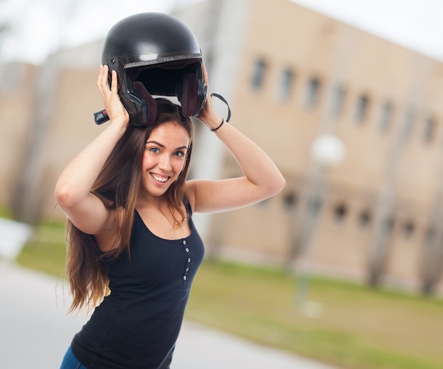 Gratis foto stralende glimlachende vrouw met zwarte helm.