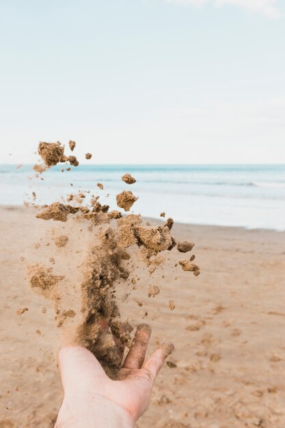 Strandconcept met hand die zand werpen