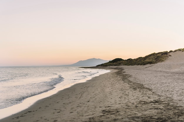 Strandlandschap bij zonsondergang