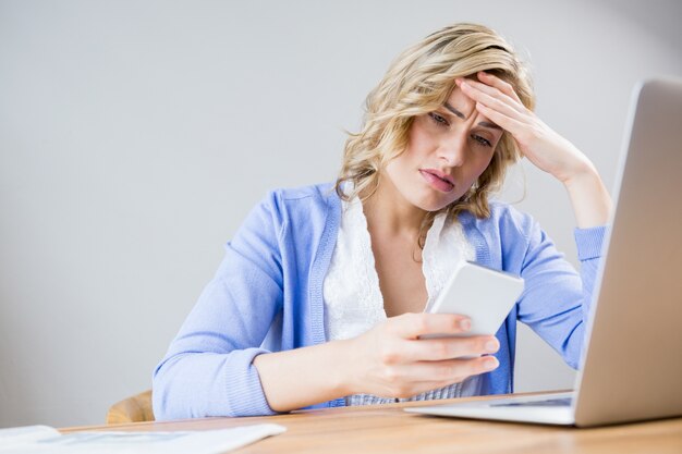 Stressed vrouw met behulp van mobiele telefoon