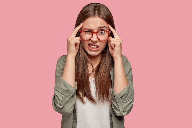 Stressvolle student poseren tegen de roze muur