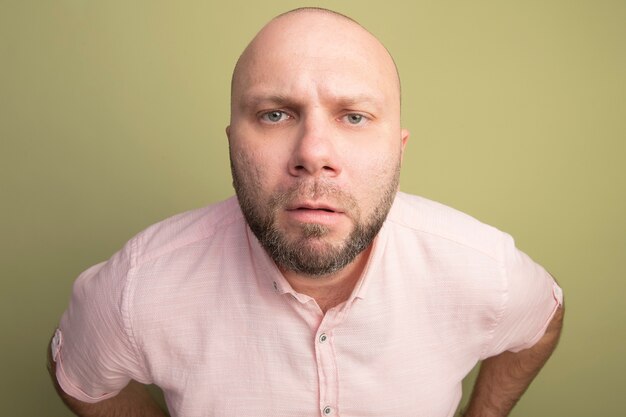 Strikte kale man van middelbare leeftijd met roze t-shirt