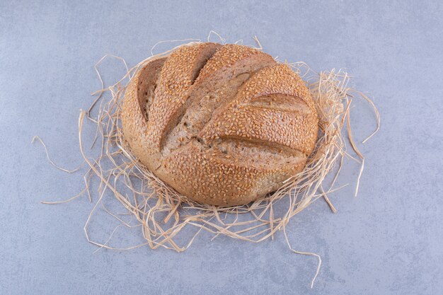 Stro stapel onder een brood op marmeren oppervlak