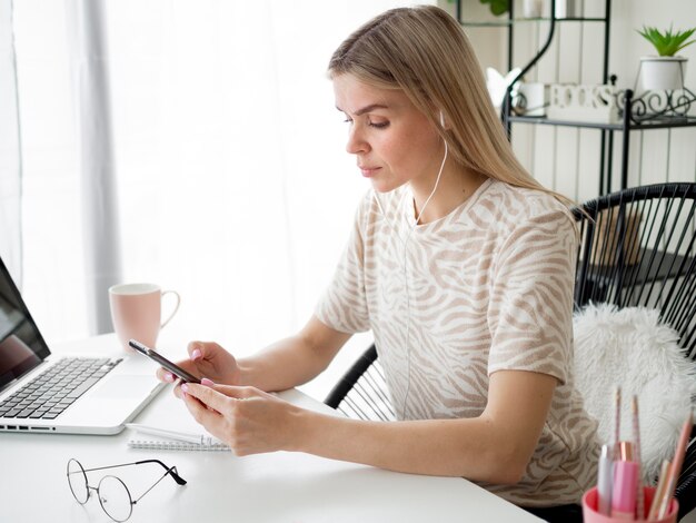 Student die haar telefoon gebruikt tijdens online cursus