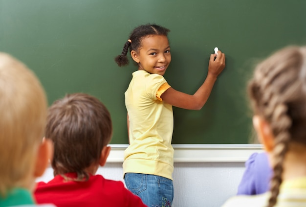 Student met gele t-shirt schrijven op het bord