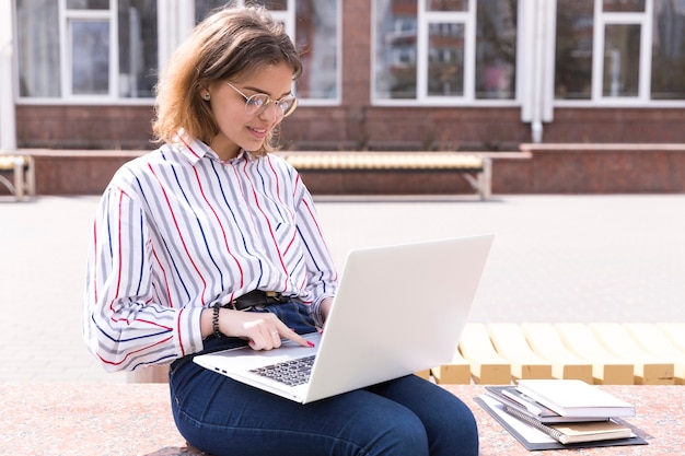 Gratis foto student met laptop en notebooks