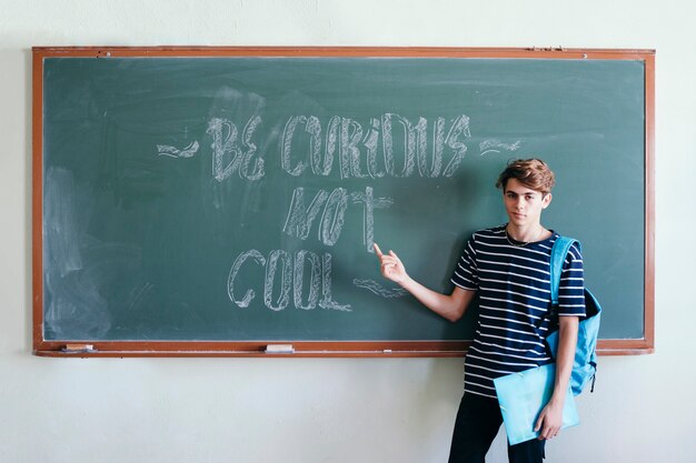 Student met rugzak die het blaadbord wijst