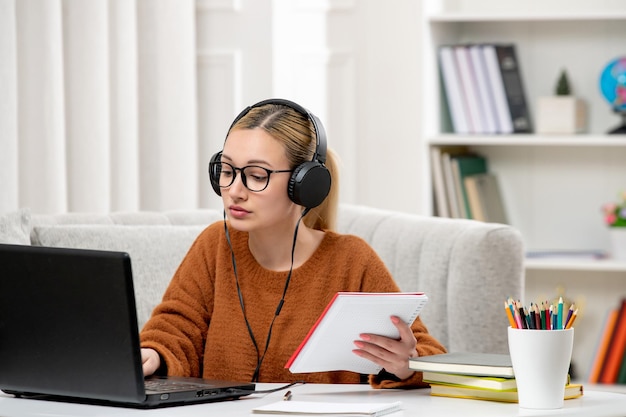 Student online schattig meisje in bril en trui studeren op computer toetsenbord typen