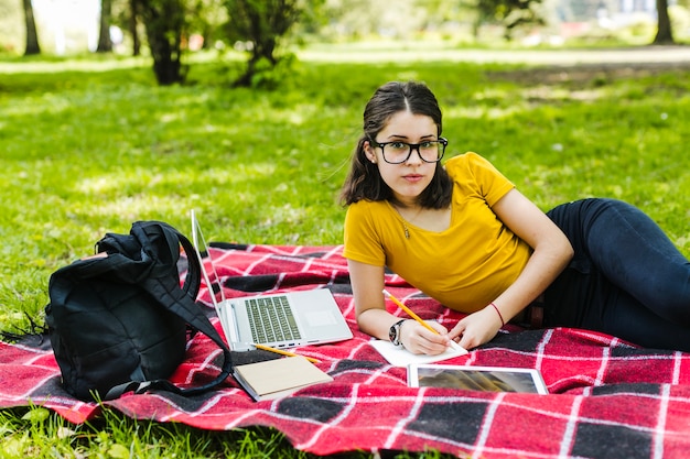 Student poseren met een bril op het gras