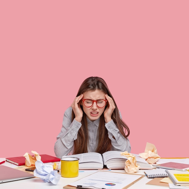 Gratis foto student zit aan bureau met documenten