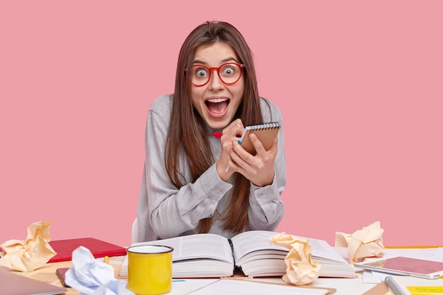 Student zit aan bureau met documenten