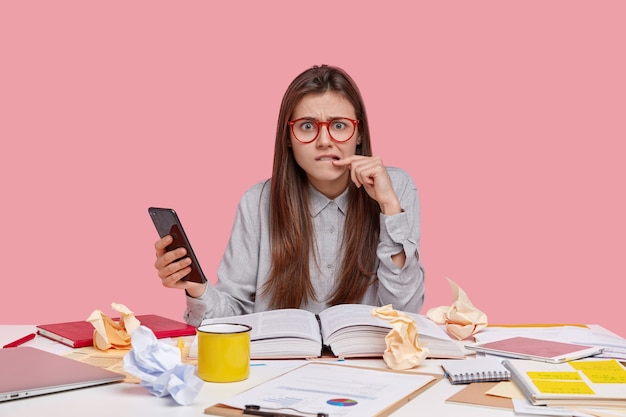 Gratis foto student zit aan bureau met documenten