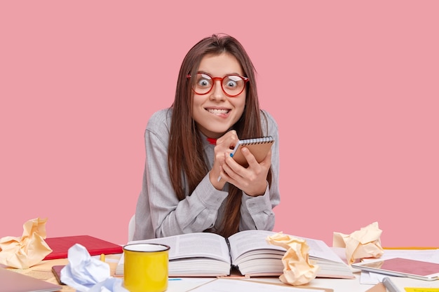 Student zit aan bureau met documenten